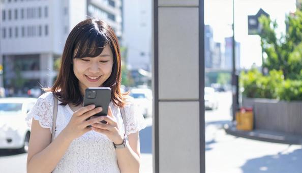 スマートフォンを操作する若い女性の写真