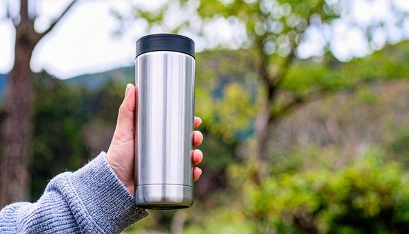 タンブラーを持つ女性の手の写真