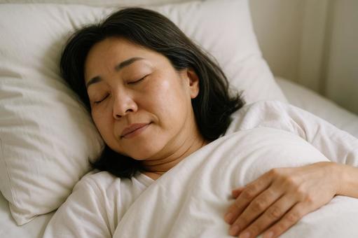 ぐっすり眠る中年女性 ぐっすり眠る中年女性の写真