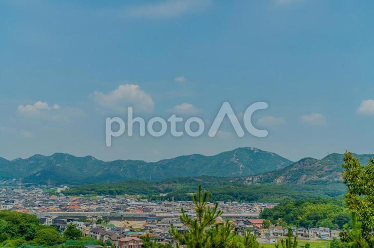 青空の下に広がる町並みと緑の山々の夏景色 山,町並み,青空の写真素材