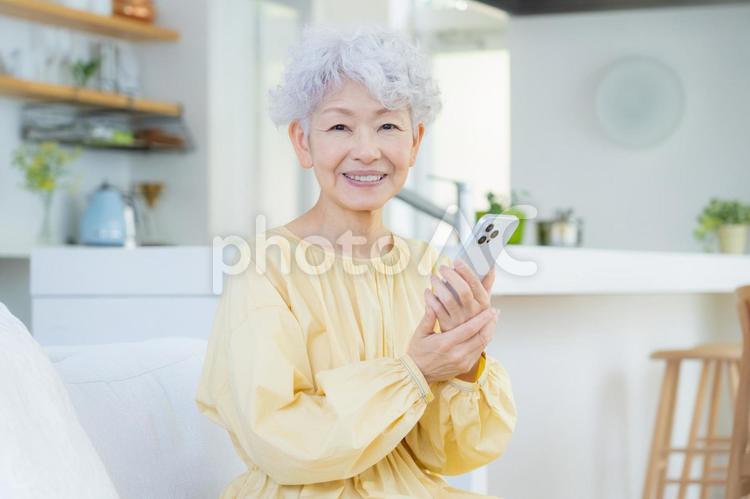 リビングでスマホを見るシニアの女性 シニア,女性,老後の写真素材
