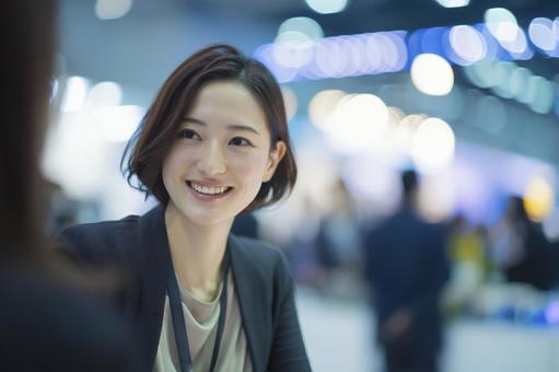 人と話す笑顔のビジネスウーマンの写真