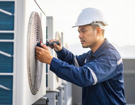 エアコン室外機を修理する男性技術者 エアコン室外機を修理する男性技術者の写真