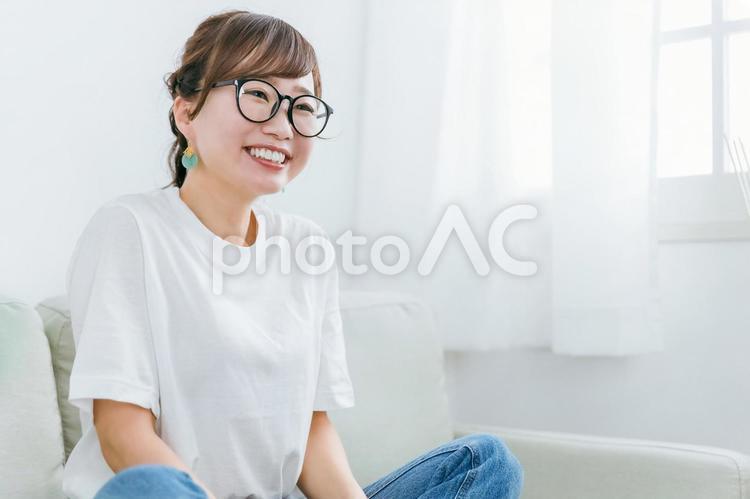 ソファに座るメガネをかけたアジア人女性 メガネ,眼鏡,女性の写真素材