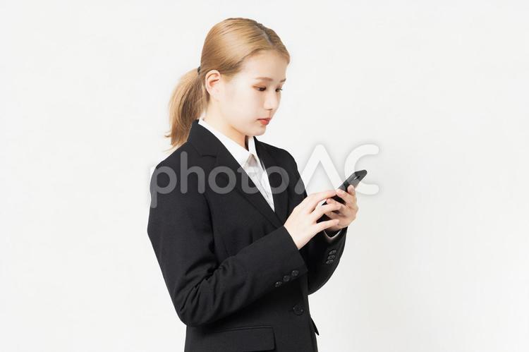 スマホを使うジャケットを着ている若い女性 スマホ,スマートフォン,使うの写真素材