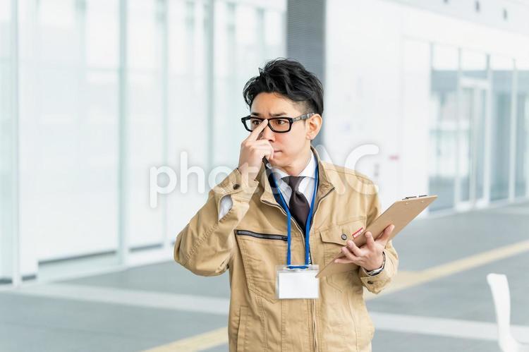 真剣な顔で眼鏡を直す作業服の男性 ビジネス,ビジネスマン,作業員の写真素材