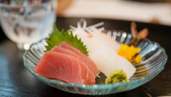 ガラスの皿に盛られた刺し身と日本酒 ガラスの皿に盛られた刺し身と日本酒の写真