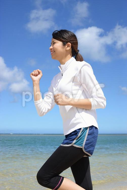 海辺でジョギングをする女性 女性,運動,健康の写真素材