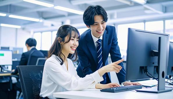 パソコンを見ながら打ち合わせをする社員 パソコンを見ながら打ち合わせをする社員の写真