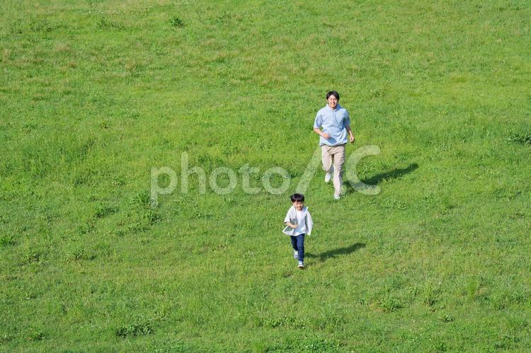 息子を追いかけ走る父 親子,走る,逃げるの写真素材