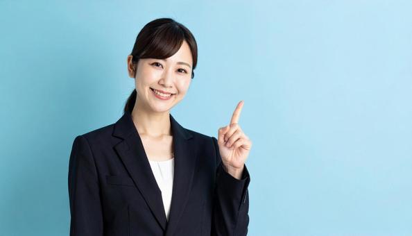 笑顔で指差すビジネスウーマンの写真