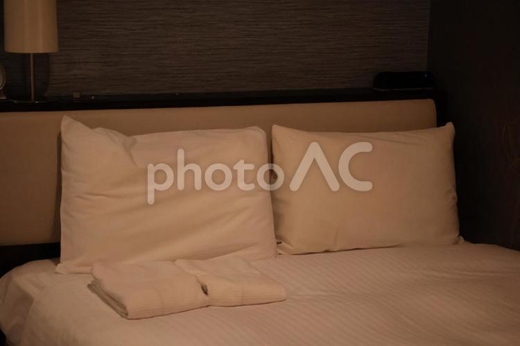枕と寝間着の置いてあるベッドの寝室 枕,寝間着,置いてあるの写真素材