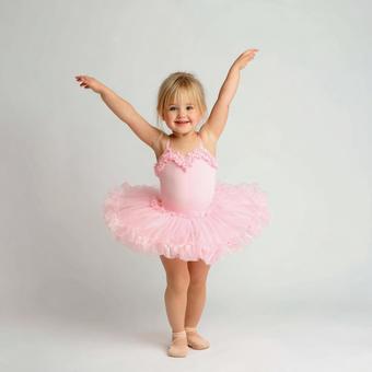 白いスタジオで踊る小さなバレリーナの写真