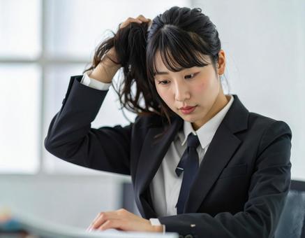 頭を抱えて頭痛に悩む女性 頭を抱えて頭痛に悩む女性の写真