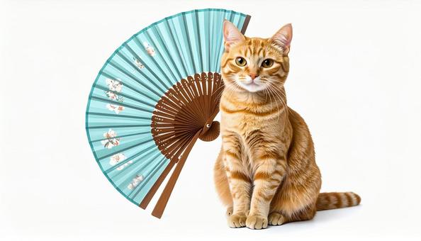 扇子の前に座る茶トラ猫の写真