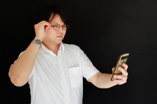 スマホを操作する眼鏡の男性 スマホを操作する眼鏡の男性 男性,スマホ,眼鏡の写真素材