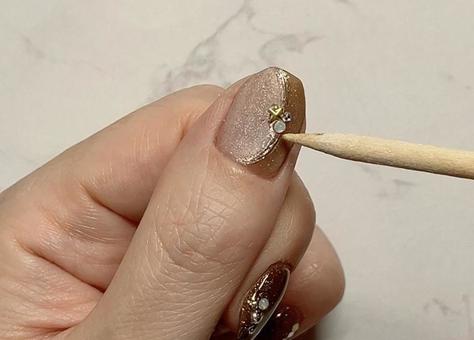 ジェルネイルを塗る女性の手元（パーツ） ジェルネイル,女性の手,セルフネイルの写真素材