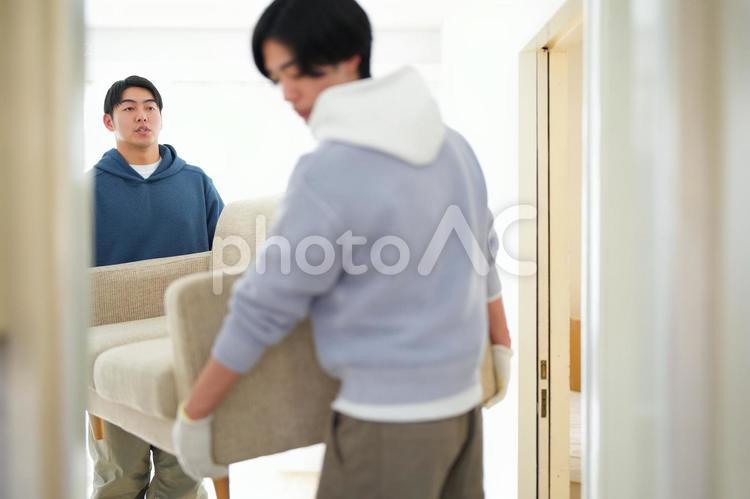 引っ越しでソファを運ぶ2人の男性 引っ越し,一人暮らし,男性の写真素材