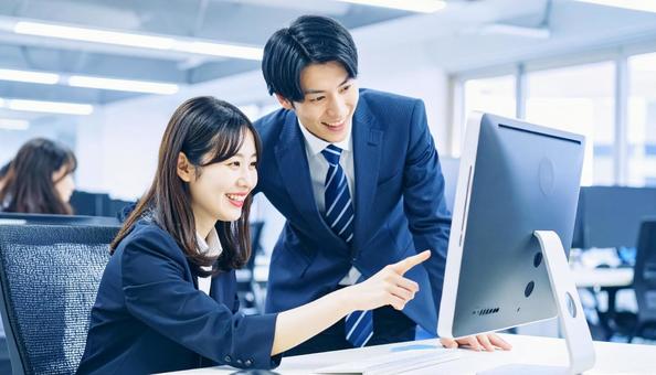 パソコンを見ながら打ち合わせをする社員 パソコンを見ながら打ち合わせをする社員の写真