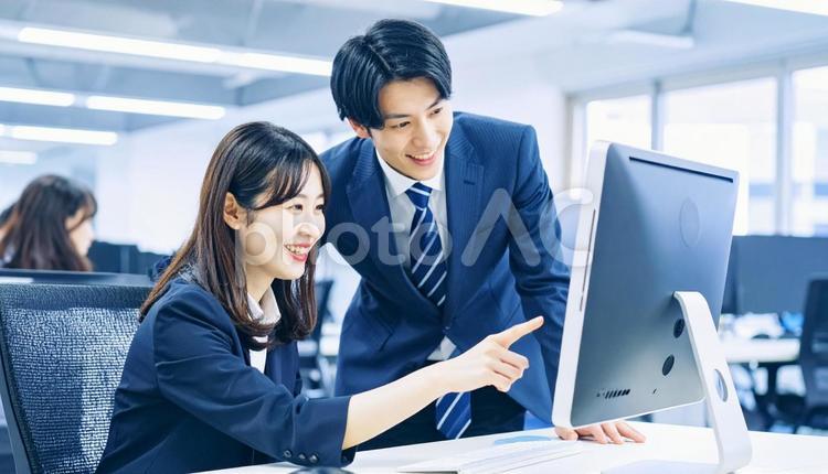 パソコンを見ながら打ち合わせをする社員 ビジネスマン,ビジネスウーマン,男女の写真素材