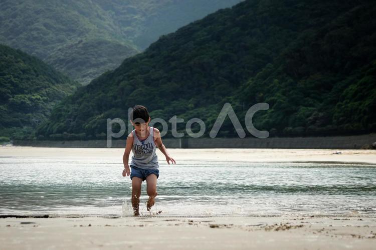 ＜素材＞夕暮れの海で水遊びをする男の子 子供,海,海水浴の写真素材