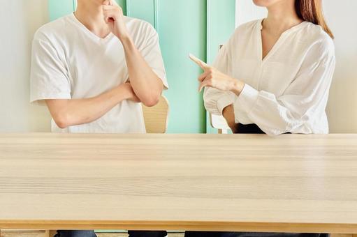 指摘する女性と考える男性 指摘する女性と考える男性の写真