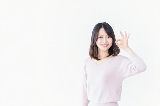 笑顔でグッドサインを示す若い女性 笑顔でグッドサインを示す若い女性の写真