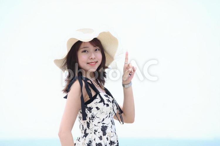 海辺で人差し指を立てる女性 女性,海辺,人差し指の写真素材