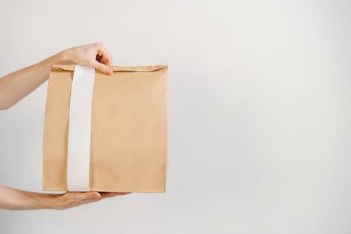 両手で紙袋を差し出す 配達,フードデリバリー,テイクアウトの写真素材