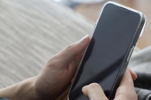 スマホを持つ男性の手 スマホを持つ男性の手の写真