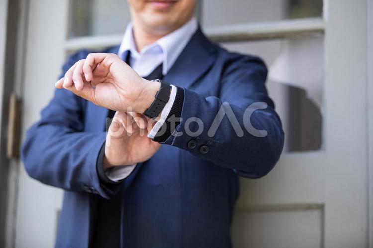 カジュアルビジネスの会社員 腕時計,時計,待ち合わせの写真素材