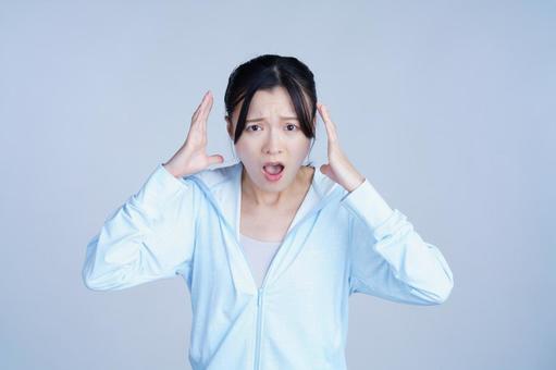 水色の服の女性が頭を抱えるの写真