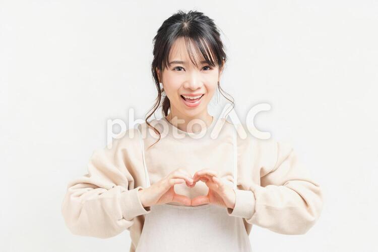 手でハートの形を作る若い女性 女性,ハート,気持ちの写真素材