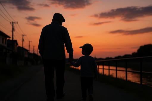 夕暮れ散歩の祖父と孫 夕暮れ散歩の祖父と孫の写真