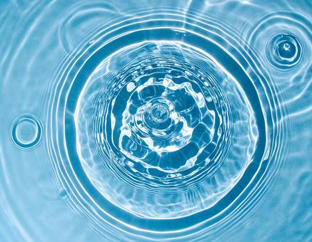 透明感のある青い水面に広がる波紋の写真