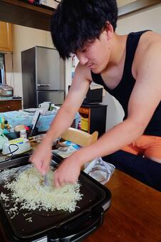 もんじゃ焼きを作るマッチョな男性 厨房,もんじゃ,もんじゃ焼きの写真素材