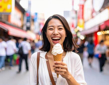 街中でアイスクリームを楽しむ笑顔の女性 街中でアイスクリームを楽しむ笑顔の女性の写真