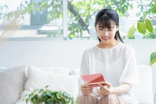 リビングで貯金通帳を見る若い女性 リビングで貯金通帳を見る若い女性 女性,リビング,ライフスタイルの写真素材