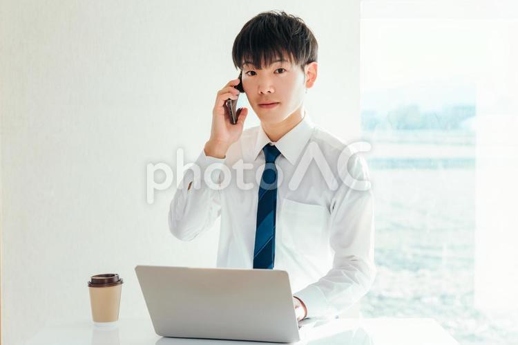 電話とパソコンを使うビジネスマン 男性,ビジネス,ビジネスマンの写真素材