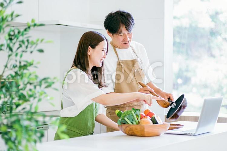 家事を手伝う男性と女性（パソコン） キッチン,夫婦,パソコンの写真素材