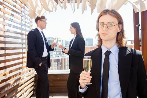 微笑みシャンパンを持つ男性後ろの男女 男性,外国人,シャンパングラスの写真素材