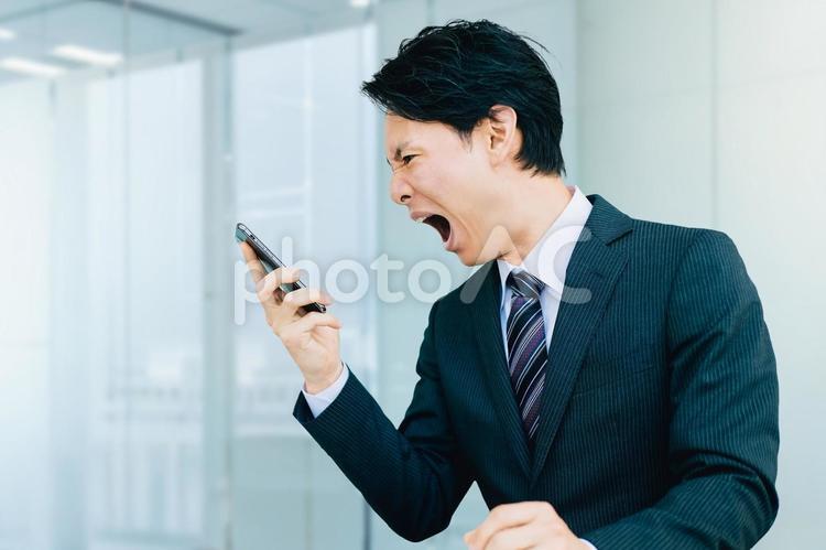 スマホに向かって大声で怒るビジネスマン 男性,ビジネス,ビジネスマンの写真素材