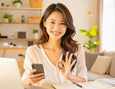 家計がうまくいきスマホ片手に微笑む女性 家計がうまくいきスマホ片手に微笑む女性の写真
