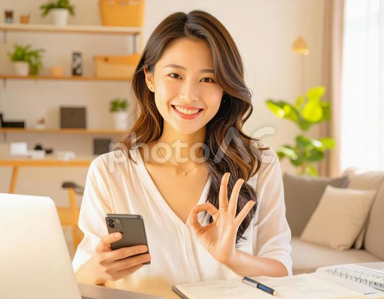 家計がうまくいきスマホ片手に微笑む女性 パソコン,家計簿,節約の写真素材