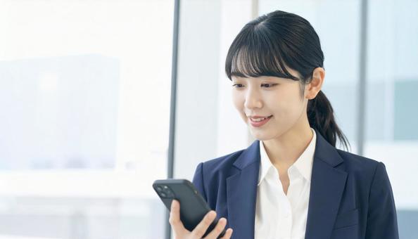 スマホを確認するビジネス女性 スマホを確認するビジネス女性の写真