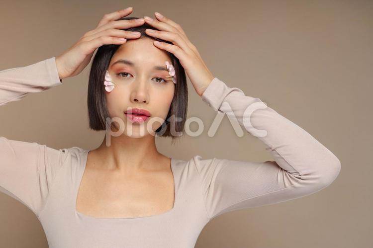 花びらを顔に付け前髪をおさえる女性 女性,前髪,おさえるの写真素材