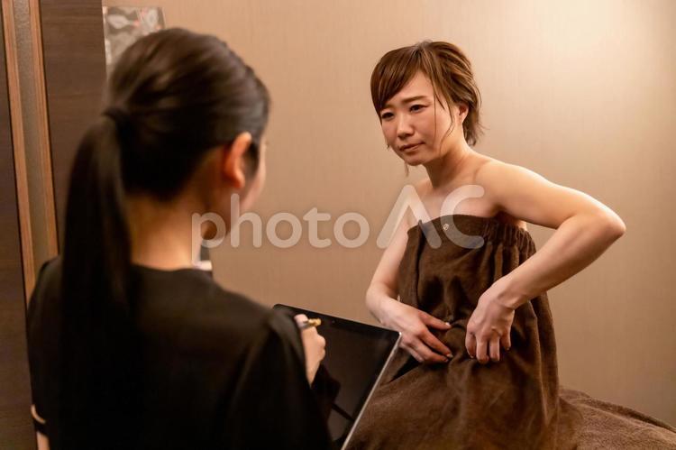 エステサロンでカウンセリングを受ける女性 脂肪吸引,脂肪溶解注射,ウエストの写真素材