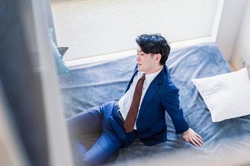 ベッドで休憩をするビジネスパーソン 日本人,休む,休憩の写真素材