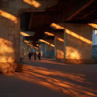 橋の下を歩く人々と夕暮れの都市風景 橋の下を歩く人々と夕暮れの都市風景の写真