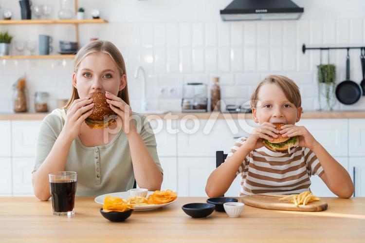 カメラ目線でハンバーガーを食べる親子 女性,男の子,親子の写真素材
